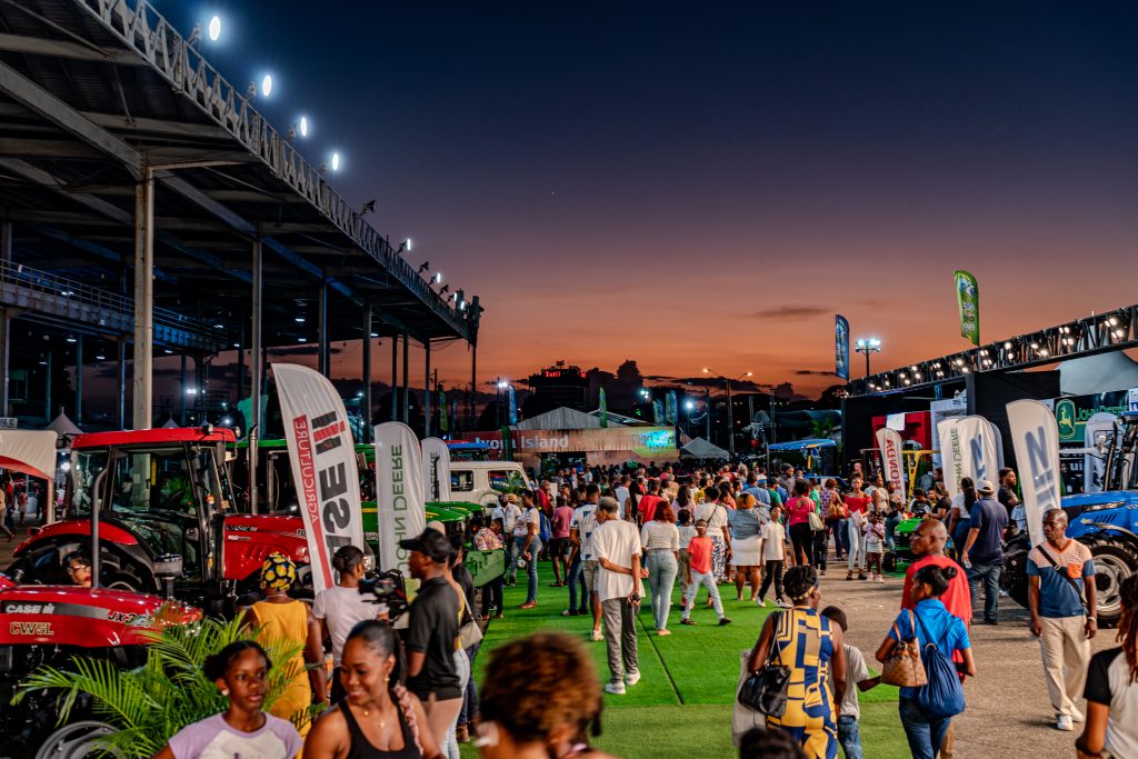 Crowd of attendees walking through the Machinery Zone at Agri-Expo 2024 during sunset
